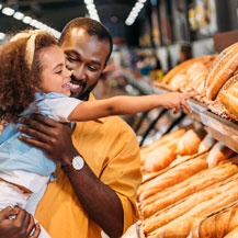 Man shopping for bread with daughter